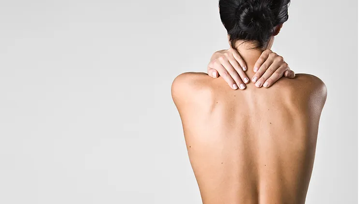 Back-Pain-Causes-Symptoms-and-Treatments A person is shown from behind, hands on their neck, indicative of discomfort or stretching.