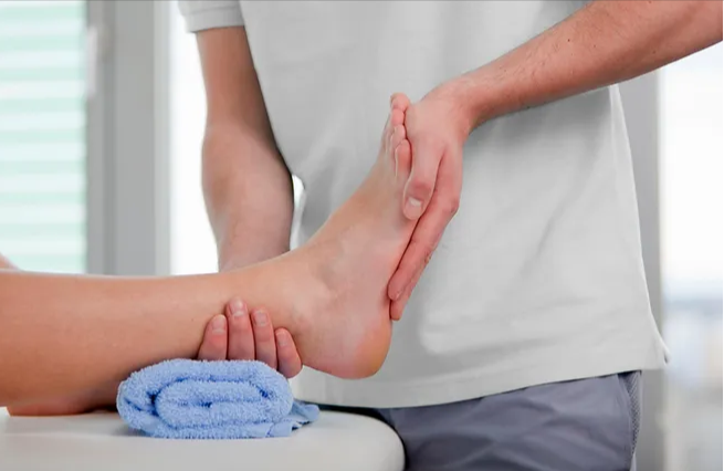 Physical-Therapy-Exercises-for-Plantar-Fasciitis-The-Best-7-Moves-to-Alleviate-Pain A close-up of a physical therapy session focusing on a patient's foot, with the therapist’s hands providing support or conducting an exercise.
