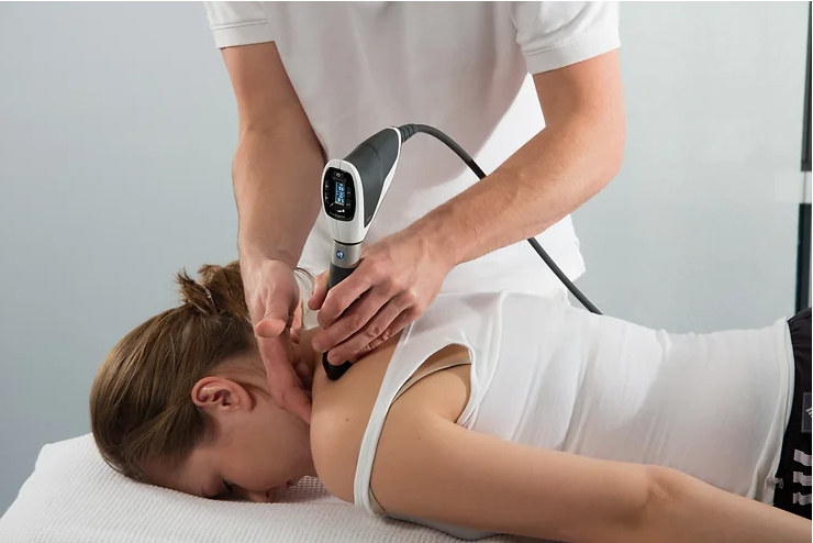 Pros-and-Cons-of-Shockwave-Therapy a shockwave therapy session where a practitioner is applying the treatment to a patient's shoulder.