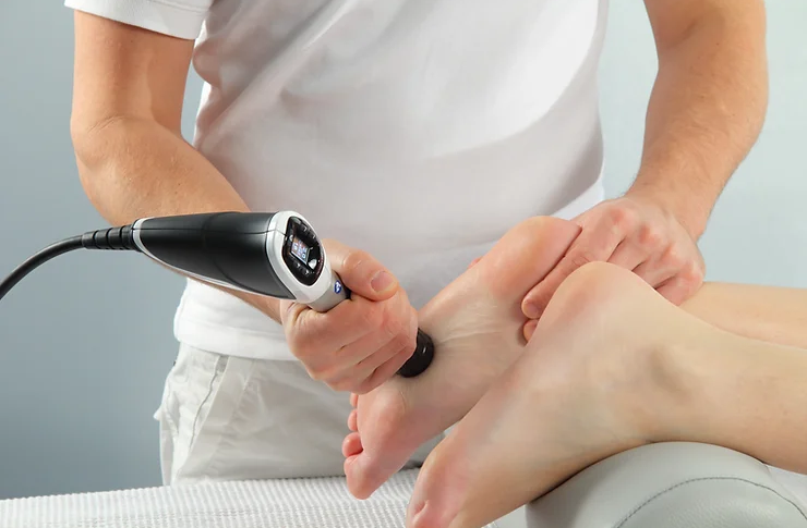What-is-EPAT-Shockwave-Therapy A healthcare professional is administering shockwave therapy to a patient's foot.